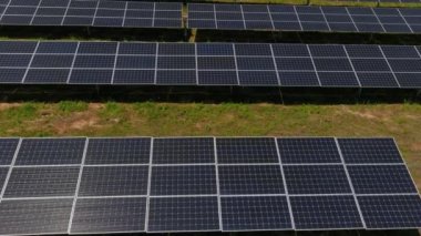 Hava manzaralı fotovoltaik paneller Yunanistan 'ın kuzeyinde yeşil alana park ediyorlar. Mavi gökyüzü güneş panellerine yansıyor. Geleceğin alternatif enerji santrali. Sürdürülebilir enerji kaynağı. Yenilenebilir elektrik teknolojisi