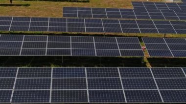 Hava manzaralı fotovoltaik paneller Yunanistan 'ın kuzeyinde yeşil alana park ediyorlar. Mavi gökyüzü güneş panellerine yansıyor. Geleceğin alternatif enerji santrali. Sürdürülebilir enerji kaynağı. Yenilenebilir elektrik teknolojisi