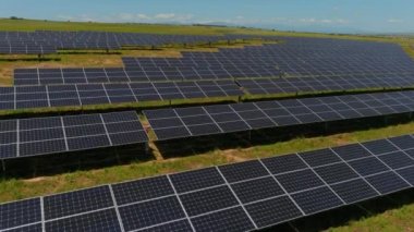 Hava manzaralı fotovoltaik paneller Yunanistan 'ın kuzeyinde yeşil alana park ediyorlar. Mavi gökyüzü güneş panellerine yansıyor. Geleceğin alternatif enerji santrali. Sürdürülebilir enerji kaynağı. Yenilenebilir elektrik teknolojisi