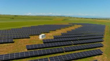 Hava manzaralı fotovoltaik paneller Yunanistan 'ın kuzeyinde yeşil alana park ediyorlar. Mavi gökyüzü güneş panellerine yansıyor. Geleceğin alternatif enerji santrali. Sürdürülebilir enerji kaynağı. Yenilenebilir elektrik teknolojisi