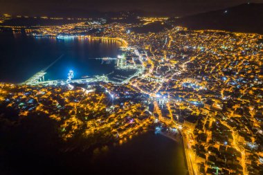 Yunanistan 'ın kuzeyindeki Kavala kenti, antik su kemeri Kamares, evler ve ortaçağ şehir duvarları gece hava manzaralı.