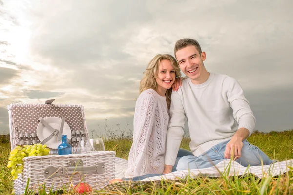 Пара сидит на пикнике под белым небом — стоковое фото
