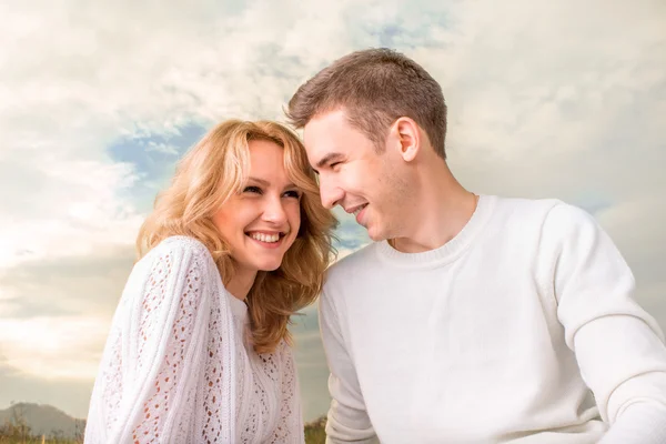 Pareja feliz sonriendo bajo el cielo soleado —  Fotos de Stock