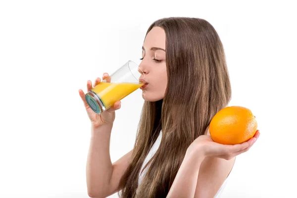 Mädchen in weißem Hemd trinkt Orangensaft vor weißem Hintergrund. — Stockfoto