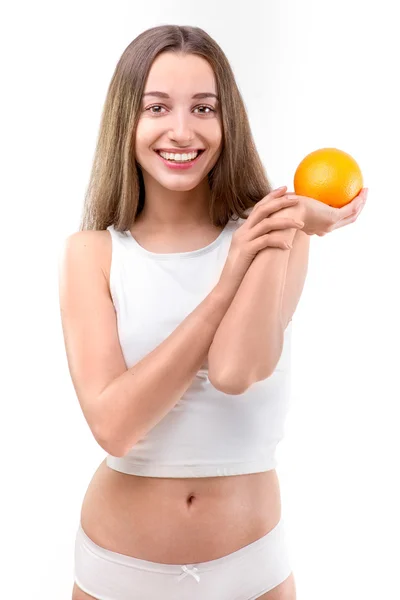 Mädchen lächelt und hält Orange auf weißem Hintergrund — Stockfoto