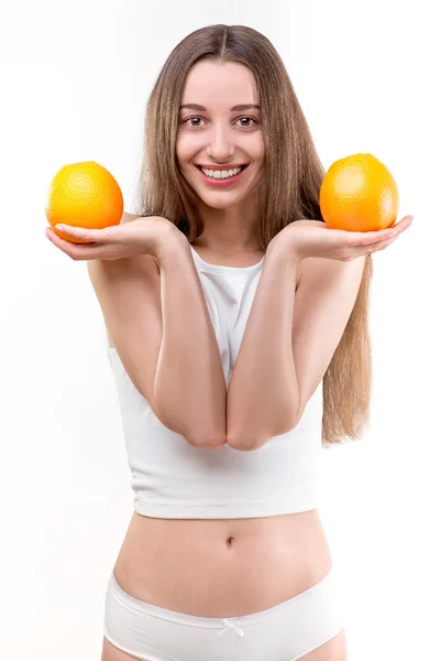 Fille souriant et tenant des oranges sur fond blanc — Photo