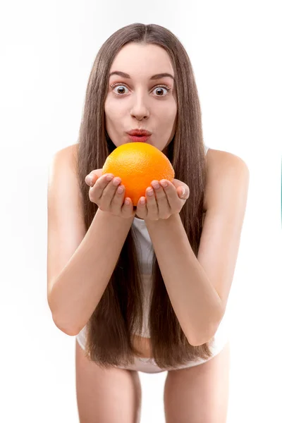 女孩抱着橙色和吹在白色背景上的橙色 — 图库照片
