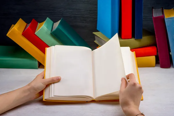 Lesebuch auf weißem Tisch mit weiteren Farbbüchern auf Hintergrund — Stockfoto