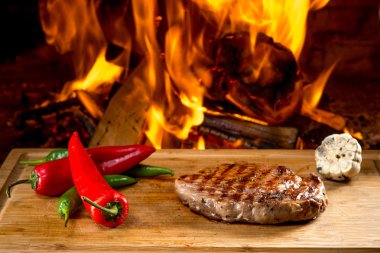 ahşap masa ve alev arka plan üzerinde lezzetli sığır eti biftek