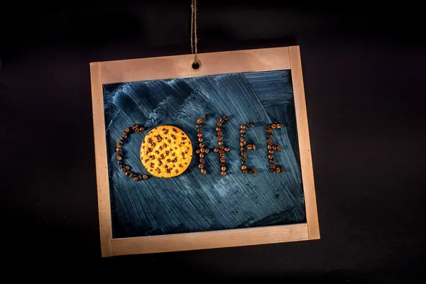 Woord koffie geschreven met koffiebonen en oatcake op schoolbord — Stockfoto