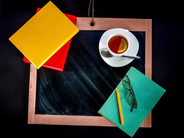 Metin alanı olan kara tahta üzerinde çay ile kitaplar — Stok fotoğraf