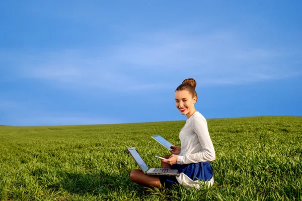 Lächelnde Geschäftsfrau mit Laptop, Tablet und Handy — Stockfoto