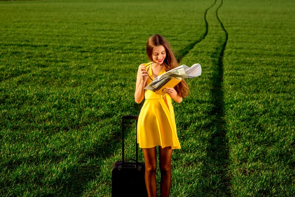 Jonge vrouw op zoek naar de kaart waar te gaan in de greenfield op — Stockfoto