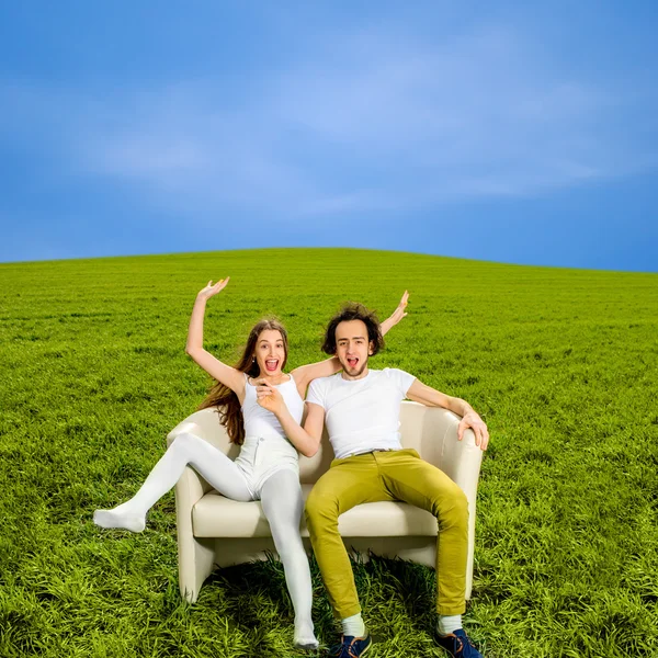 Překvapen a šokován pár sedící na gauči v zelené f — Stock fotografie