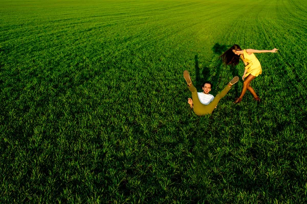 年轻的夫妇在绿色的原野上尽情的在春天或汇总 — 图库照片