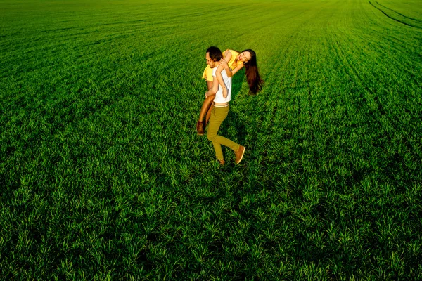 Jeune couple s'amusant sur le champ vert au printemps ou en été — Photo