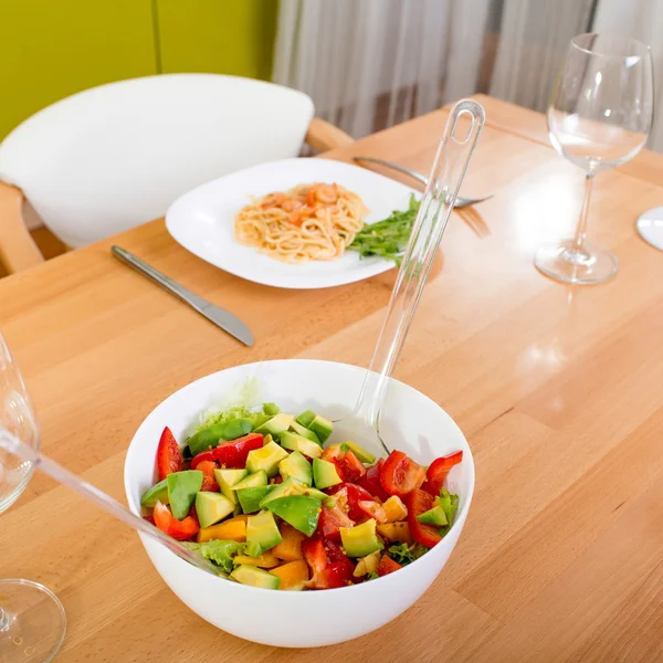 Salată pe masa de cină cu paste și pahare de vin — Fotografie, imagine de stoc