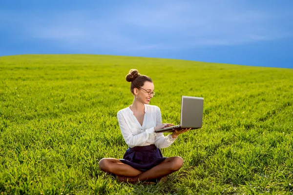 Jeune femme, fille travaillant avec un ordinateur portable dans un champ vert, parc avec — Photo