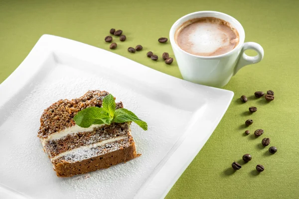 Ein Stück Karottenkuchen auf grünem Hintergrund mit Kaffee — Stockfoto