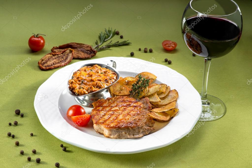 Escalope of pork with potato chips on the green background