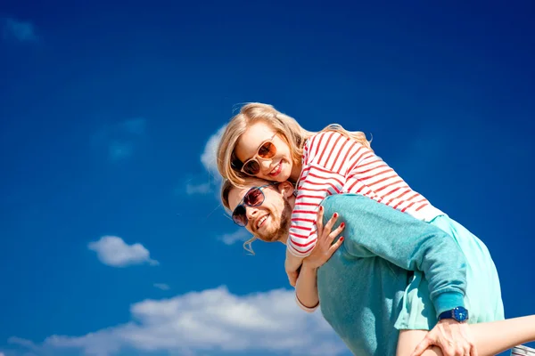 Casal feliz abraçando e se divertindo sob o céu azul — Fotografia de Stock