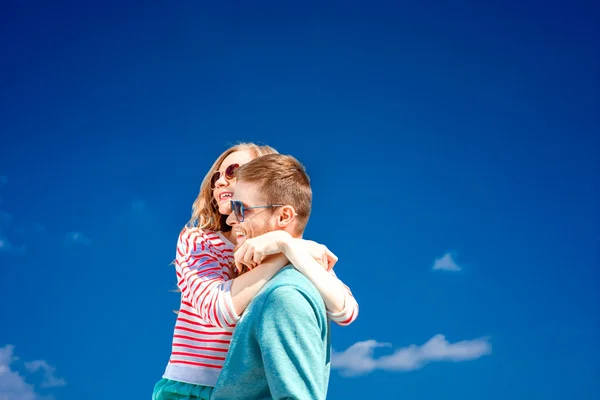 Feliz pareja abrazando y divirtiéndose bajo el cielo azul — Foto de Stock