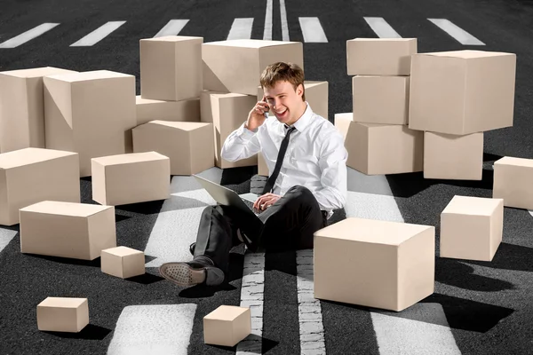 Confident and successful businessman sitting on the road and spe — Stock Photo, Image