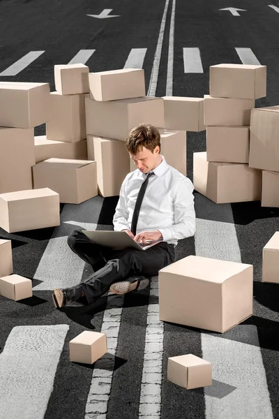 Confident and successful businessman sitting on the road and wor — Stock Photo, Image