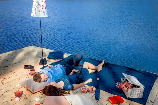 Couple  lying on terrace near the water — Stock Photo, Image