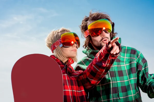 Женщина указывает пальцем на мужчину где-то одетый в лыжные костюмы — стоковое фото