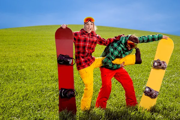 Couple in ski suit having fun with snowboards on the grass in gr — Stock Photo, Image