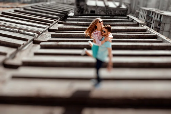 Young couple having fun on the gray roof of apartment building i — Stock Photo, Image