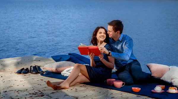 Paar zitten en lezen op het terras in de buurt van het water — Stockfoto