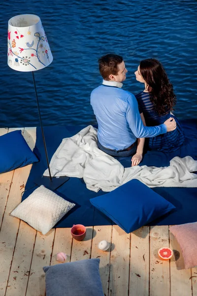 Jeune couple amoureux se détendre sur la terrasse près de l'eau — Photo