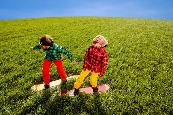 Kleurrijke paar snowboarden op het gras in de greenfield — Stockfoto