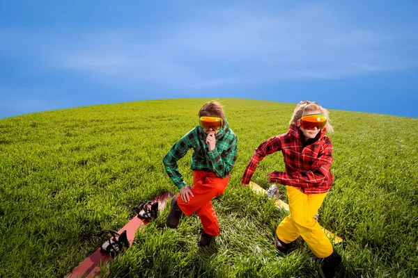 Paar plezier in skipakken met snowboards op het gras — Stockfoto