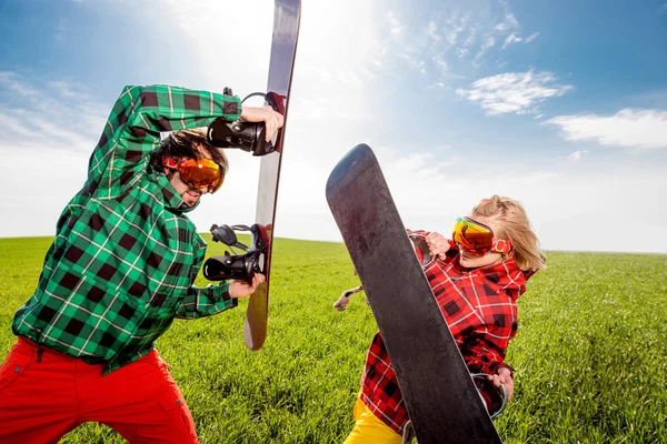 Jeune couple en combinaison de ski ont bataille amusante avec snowboards ensemblele — Photo