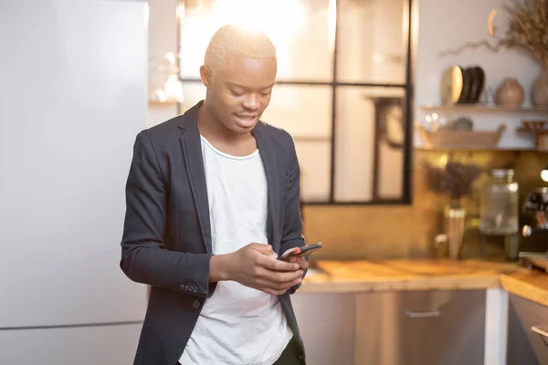 Homem negro assistindo algo no smartphone — Fotografia de Stock