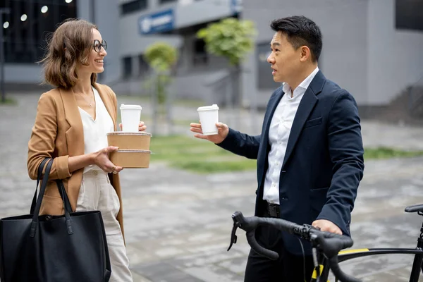 コーヒーを飲みながら街で話をするビジネスマン — ストック写真