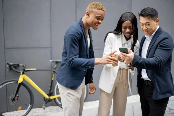 スマートフォンで見ているビジネス人のグループ — ストック写真