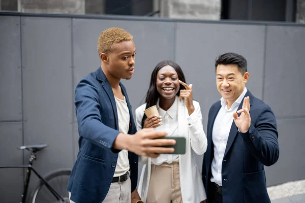 Multiracial business team taking selfie on phone — Stock Photo, Image