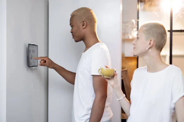 Mann wählt Temperatur von Smart Home in der Nähe von Mädchen — Stockfoto