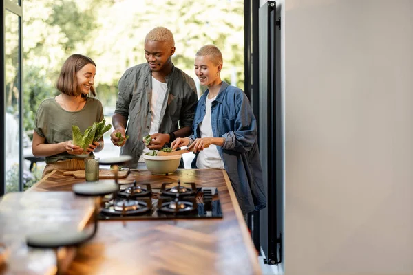 Vänner matlagning sallad tillsammans hemma kök — Stockfoto