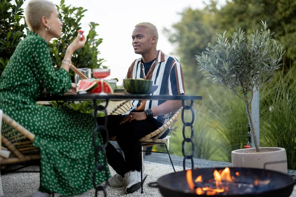 Çok ırklı bir çift arka bahçelerinde yemek yiyor. — Stok fotoğraf