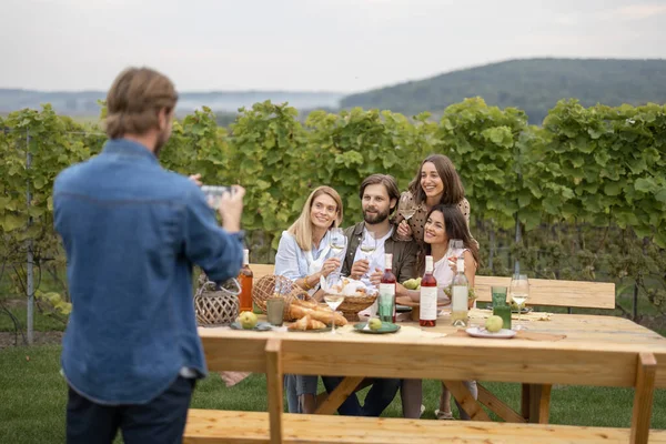Man neemt foto 's op smartphone van vrienden bij picknick — Stockfoto