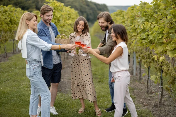 Přátelé ochutnávka vína v blízkosti vinic na venkově — Stock fotografie