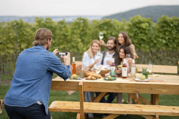 Piknikte arkadaşlarının akıllı telefonuyla fotoğraf çeken bir adam. — Stok fotoğraf