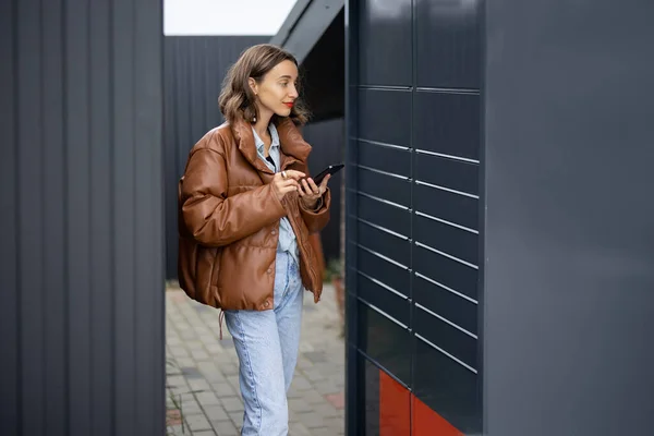 Caucásico chica usando smartphone cerca de post terminal — Foto de Stock