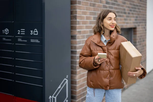 Caucasian woman with parcel near post terminal
