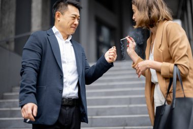 İnsanlar teneffüste sigara içiyor.